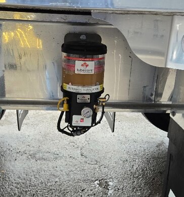 Automatic greasing system installed beneath truck equipment
